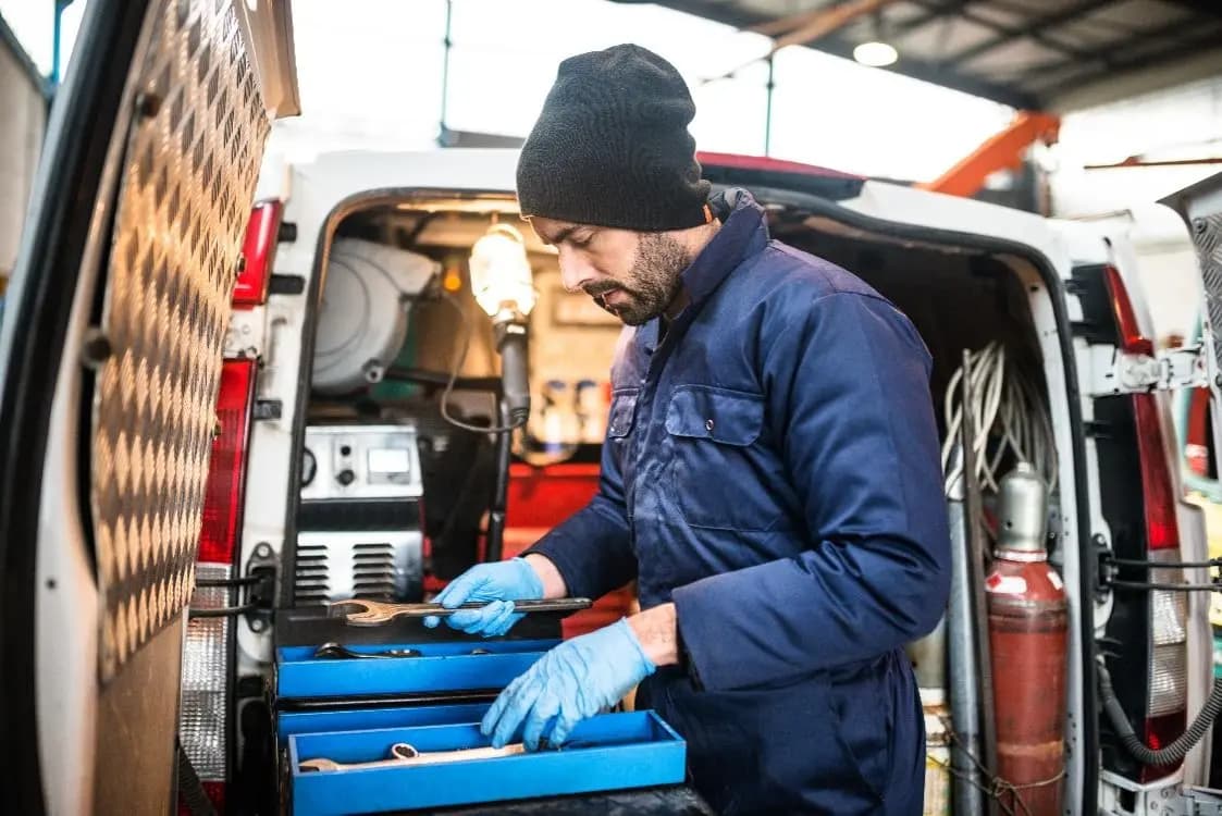 Mechanic organizing tools in a service van