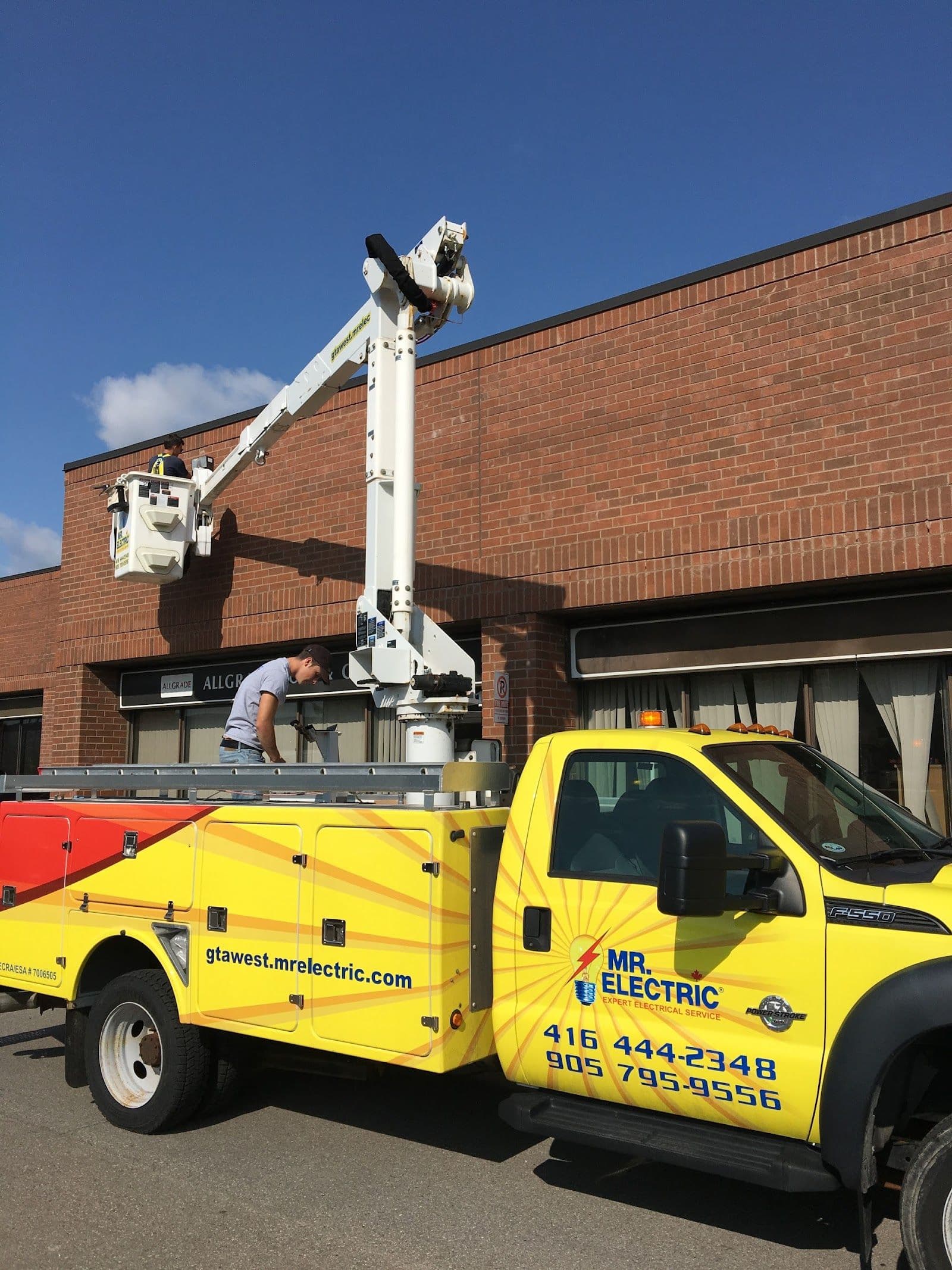 Two electricians in a work van reviewing customer feedback and Google reviews on a tablet after completing a residential job in the GTA West area