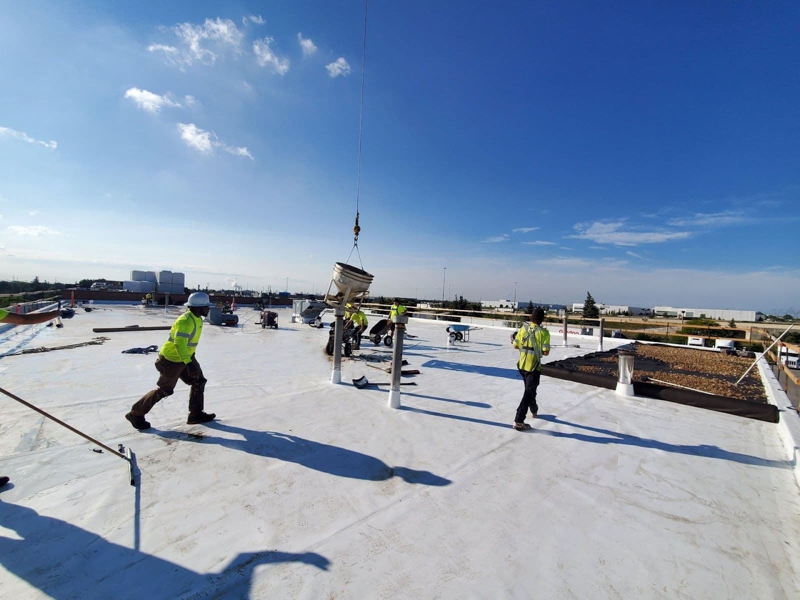 A roofing crew reviewing customer feedback together on a tablet while seated in their work van before a job