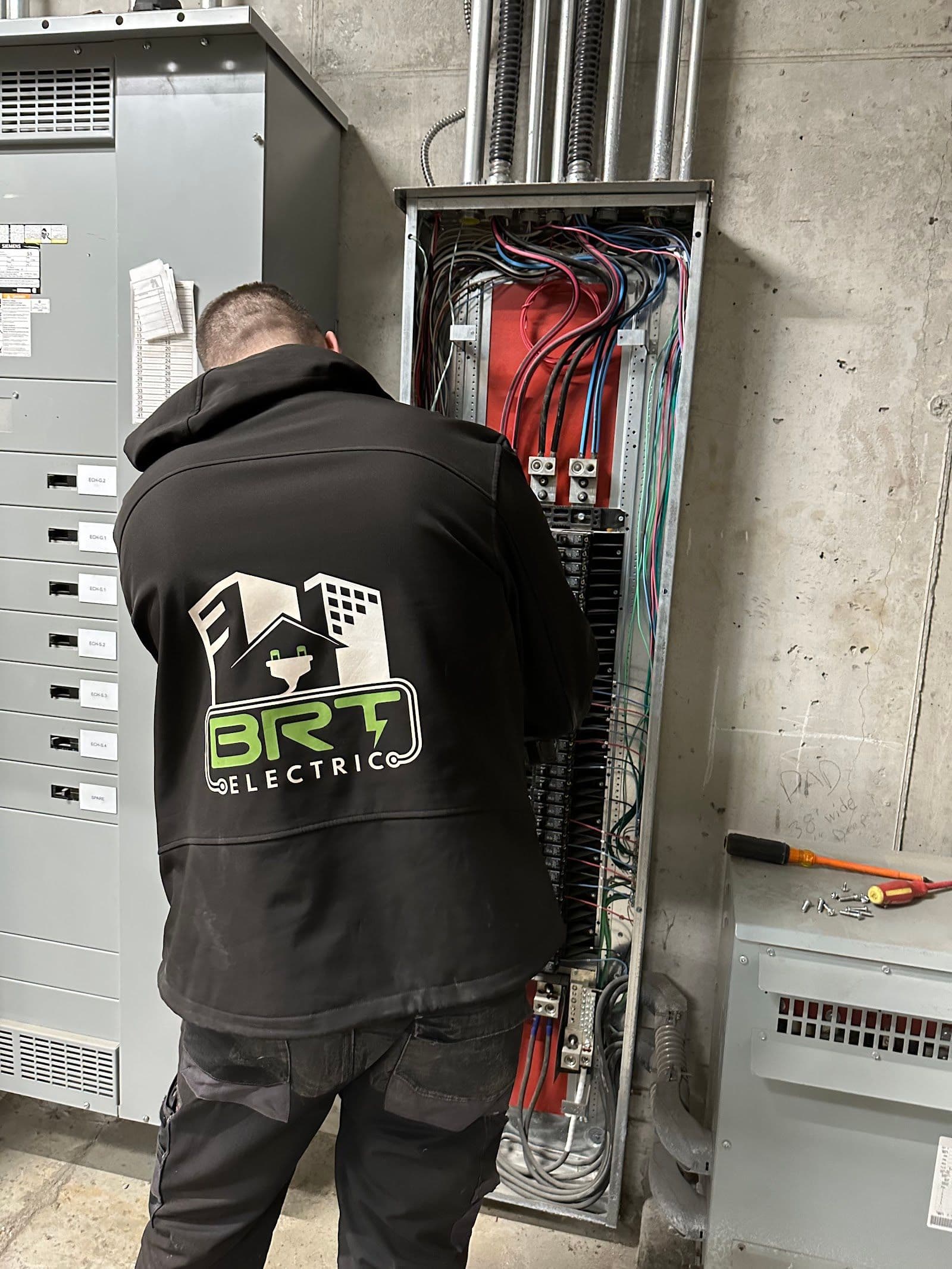 Two electricians in a work van reviewing customer feedback and Google reviews on a tablet after completing a job on site