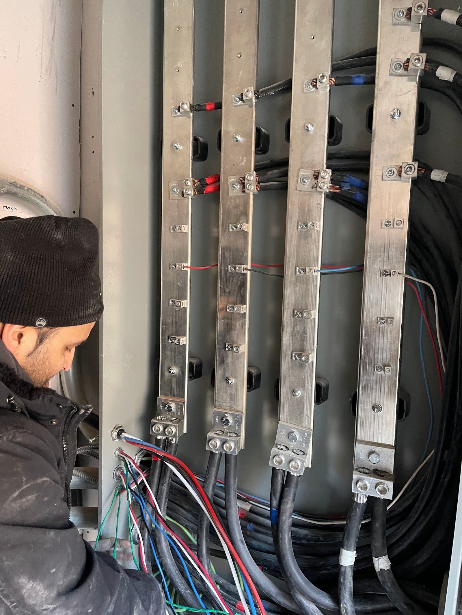 An electrician and office manager reviewing customer feedback together on a tablet inside a work van, tools and equipment visible in the background