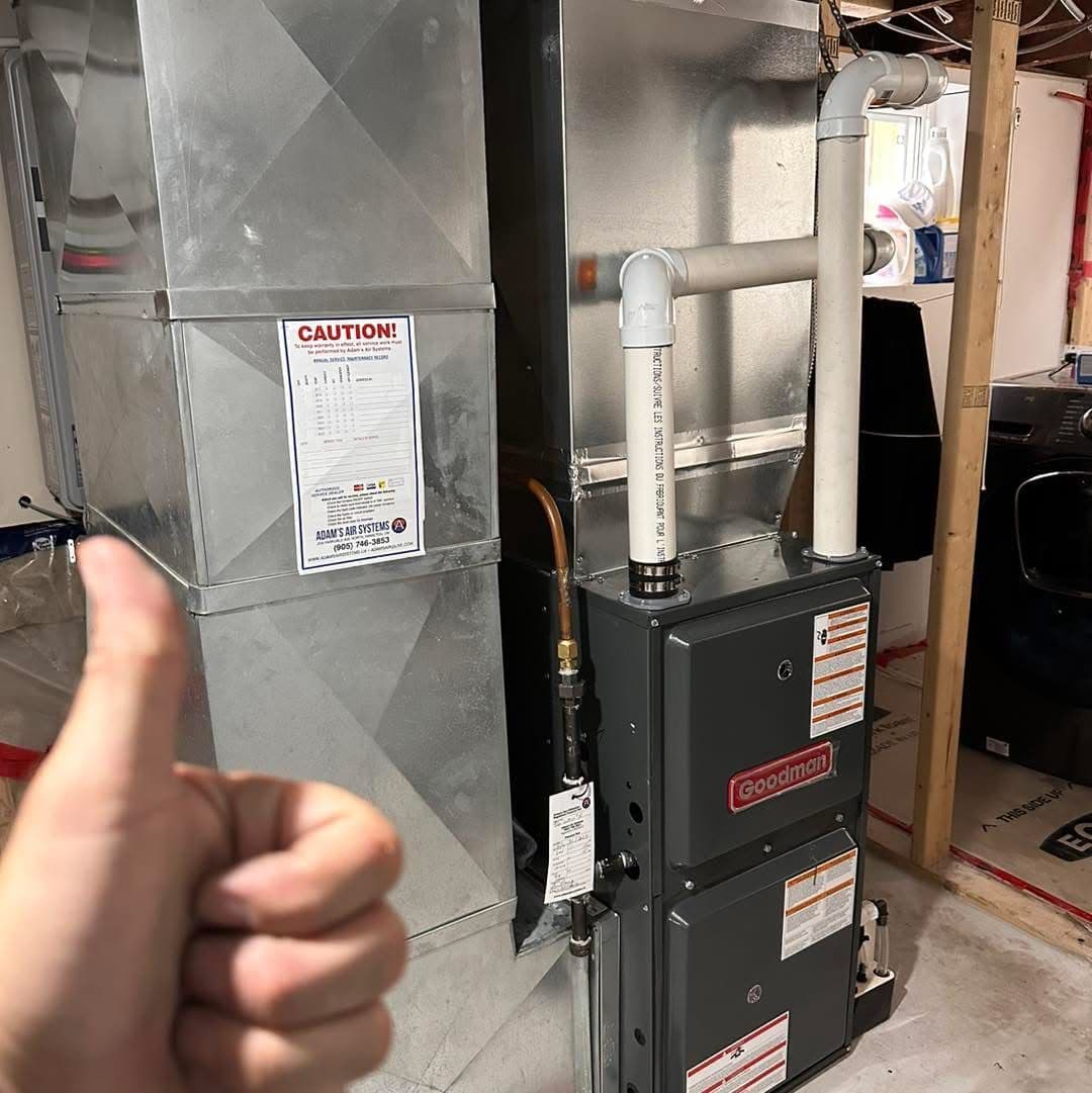 Two HVAC technicians in a service van reviewing customer feedback and Google reviews together on a tablet after completing a furnace installation