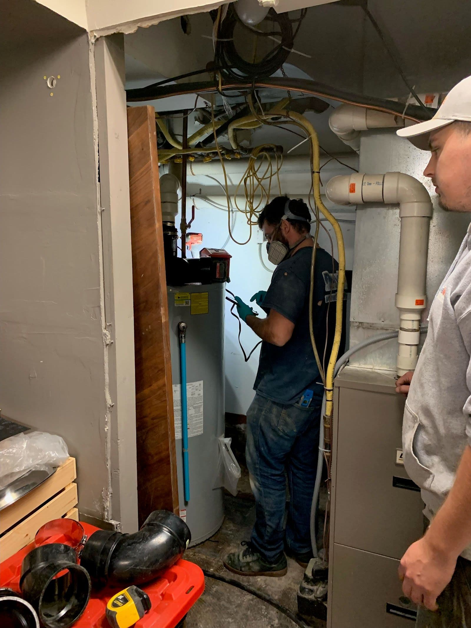 A plumbing technician and office manager reviewing customer feedback together on a tablet inside a service van parked at a Hamilton job site