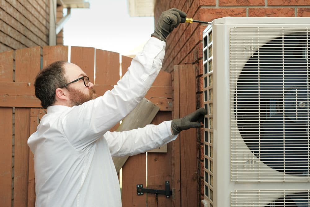 A heating and air conditioning technician reviewing customer feedback on a tablet inside a service van before heading to the next job