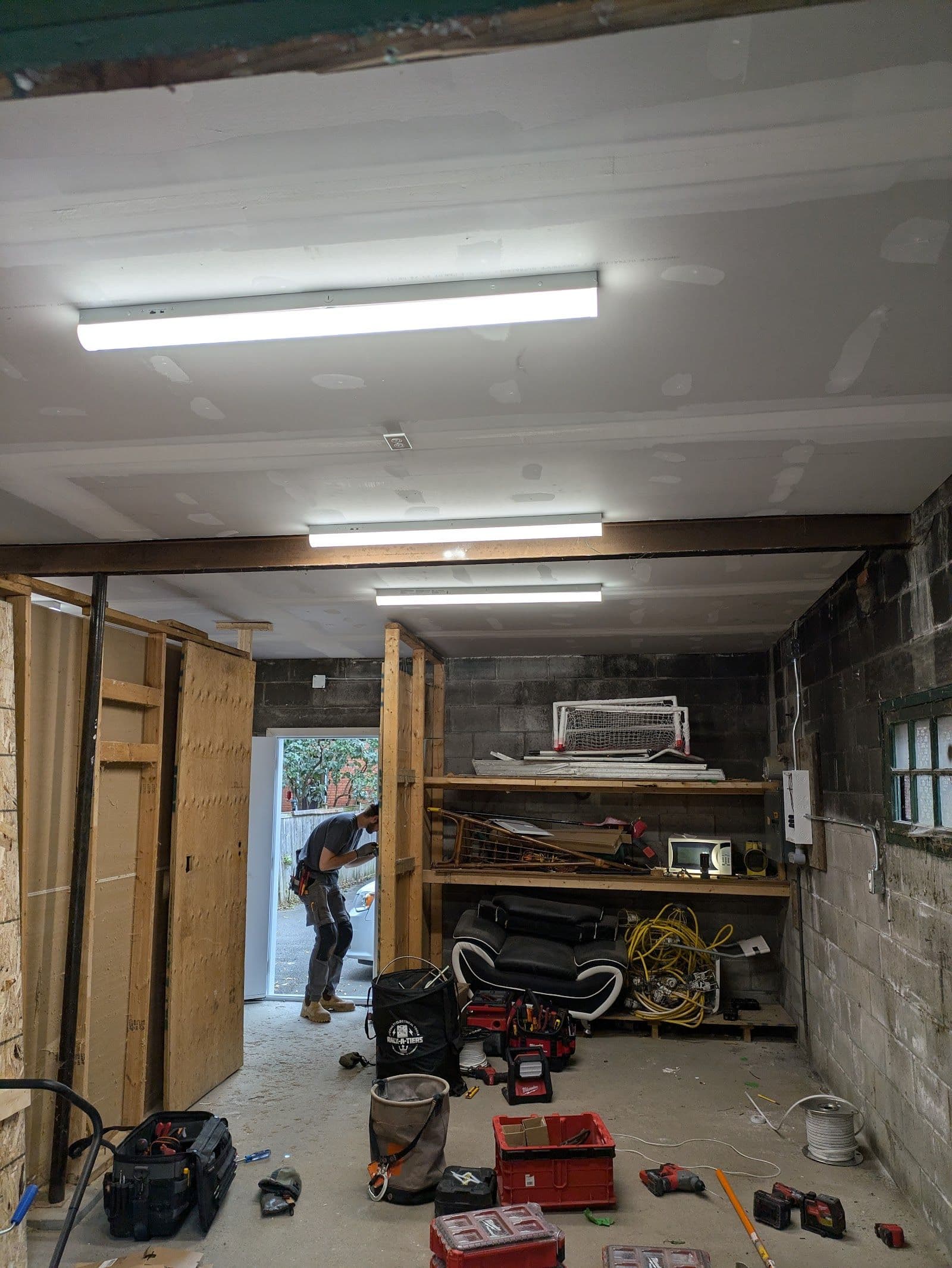 Two electricians in a service van reviewing customer feedback and job notes on a tablet before heading to a residential panel upgrade