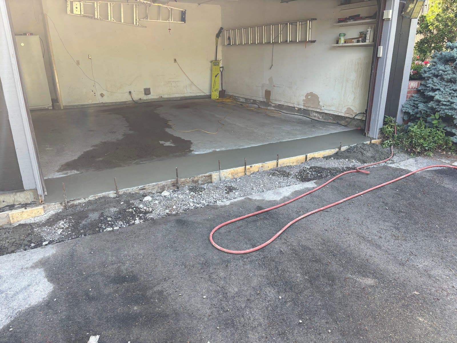 A paving crew reviewing customer feedback on a tablet while standing beside their work truck at a freshly completed driveway job