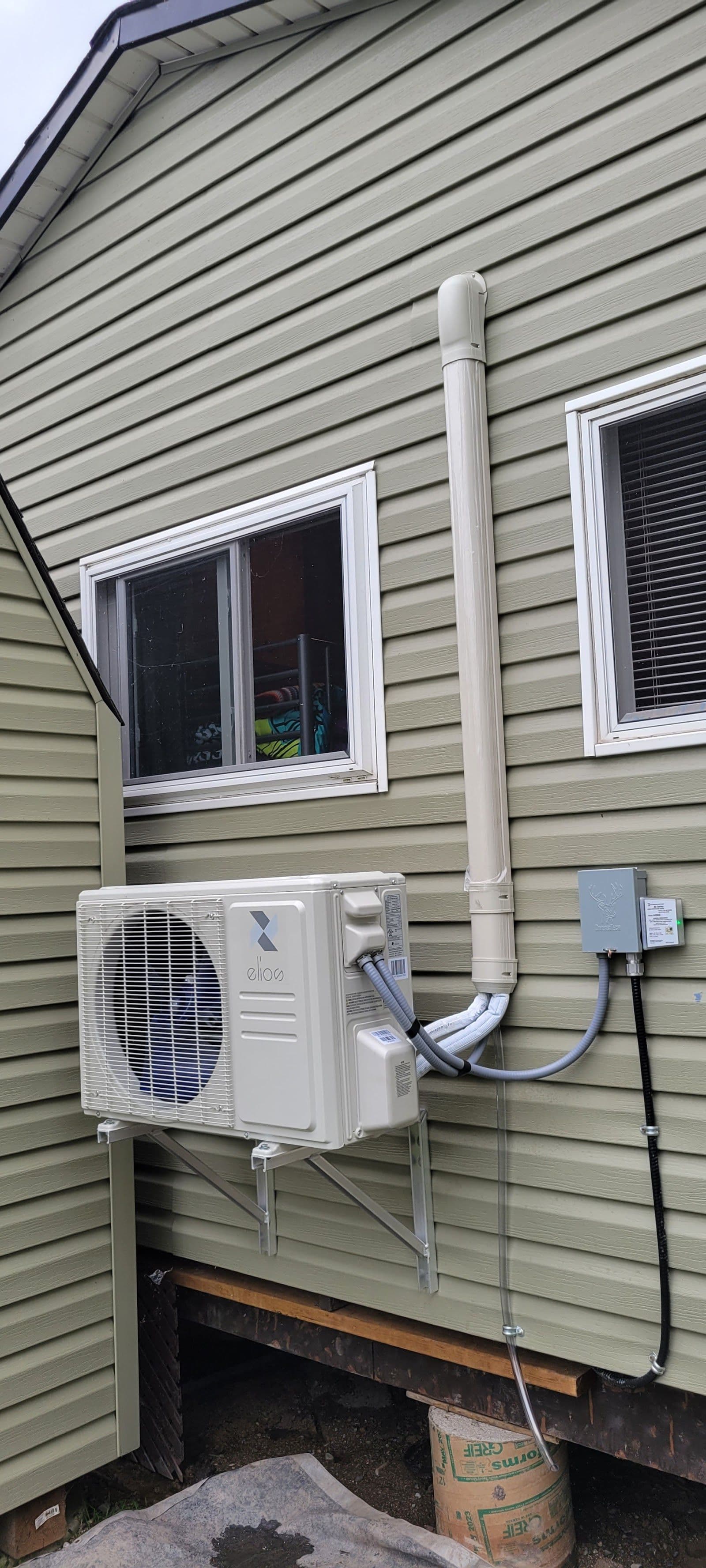 HVAC technician and office manager reviewing customer feedback on a tablet while sitting in a service van outside a Hamilton home