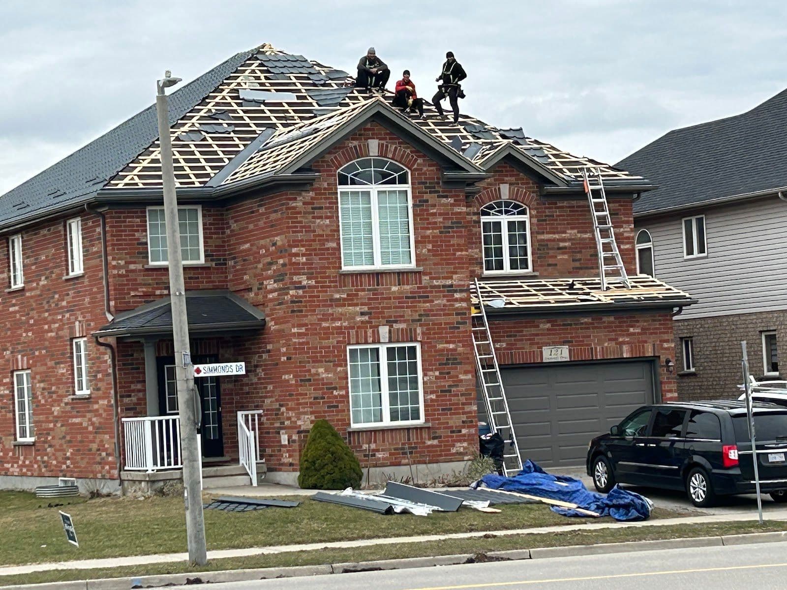 A roofing contractor and office manager reviewing customer feedback together on a tablet while standing next to a work truck at a job site