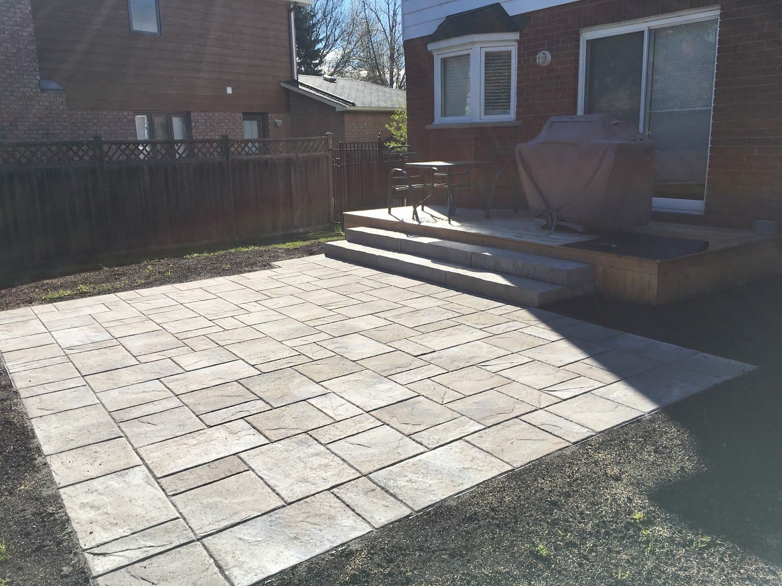 A paving crew reviewing customer feedback on a tablet beside their work truck after completing a residential driveway job in Ottawa