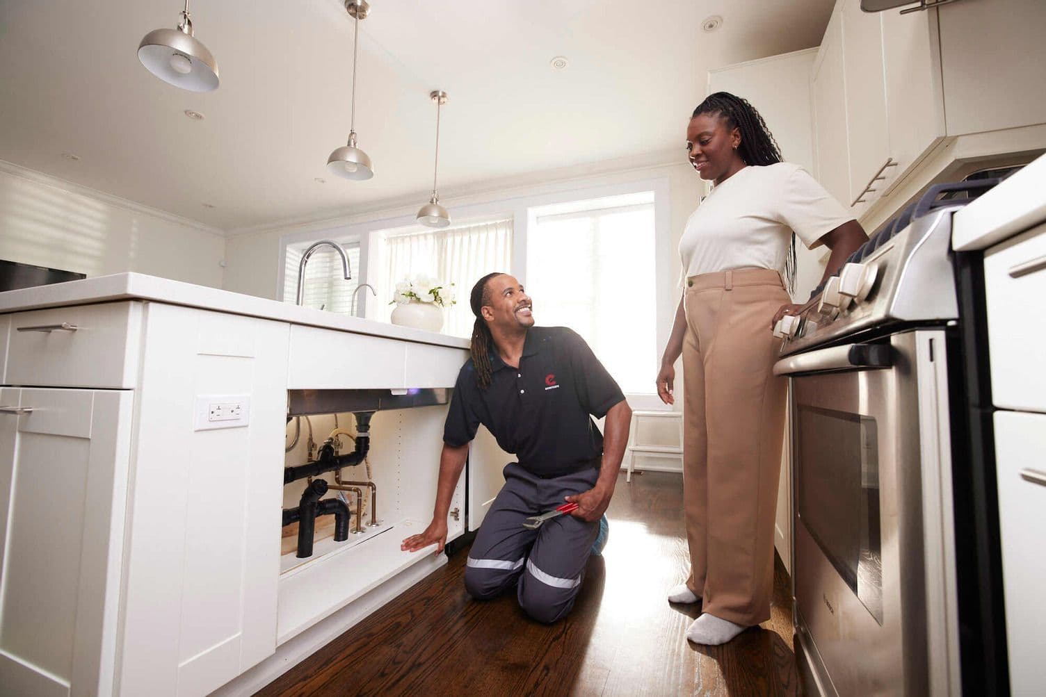 Two home service technicians in a work van reviewing customer feedback and recent Google reviews on a tablet after completing a plumbing and water softener job