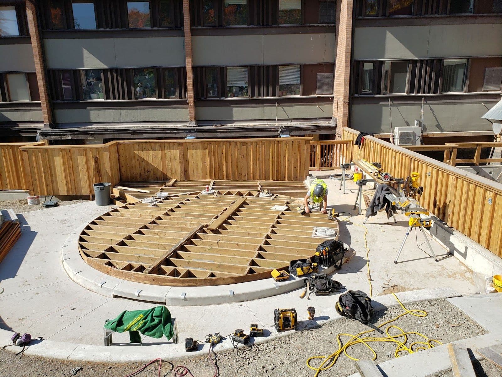 A construction crew reviewing customer feedback on a tablet outside their work van at a residential job site in Canada.