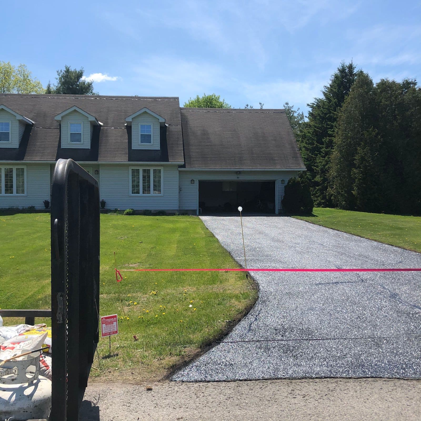 Two asphalt crew members reviewing customer feedback together on a tablet beside their work truck on a residential driveway