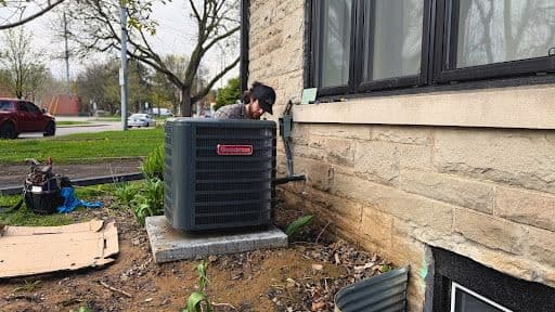 Two home service technicians reviewing customer feedback together on a tablet inside a service van, with HVAC equipment visible in the background