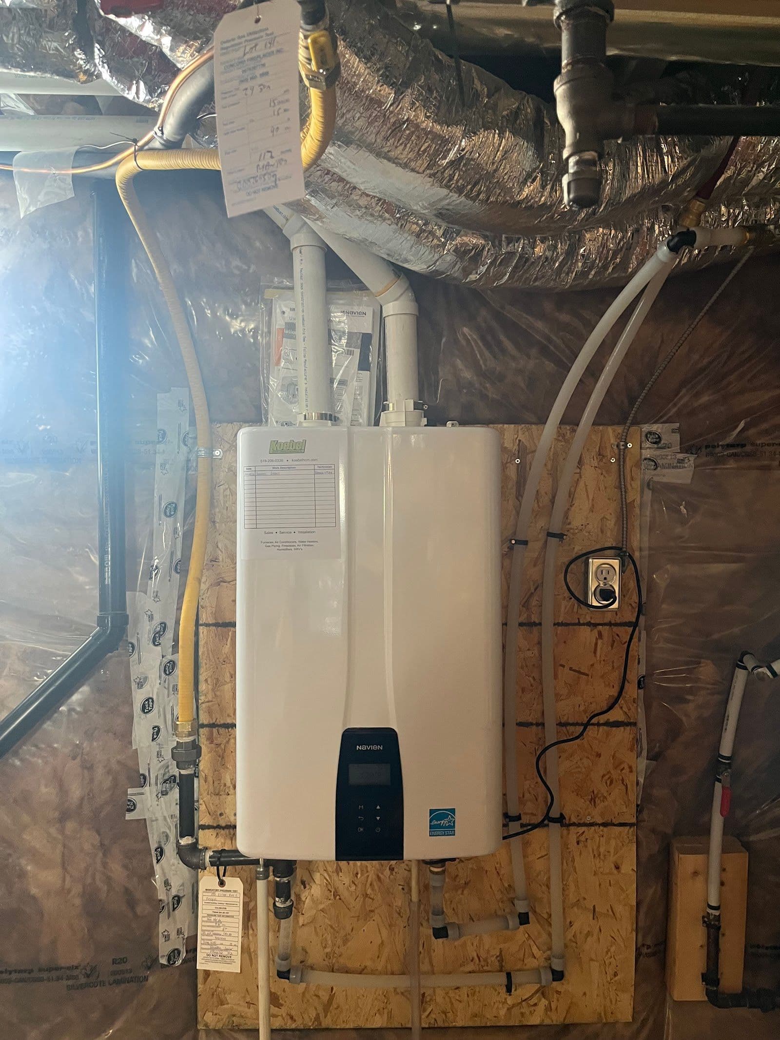 Two HVAC technicians in a service van reviewing customer feedback and Google reviews on a tablet after completing a furnace installation